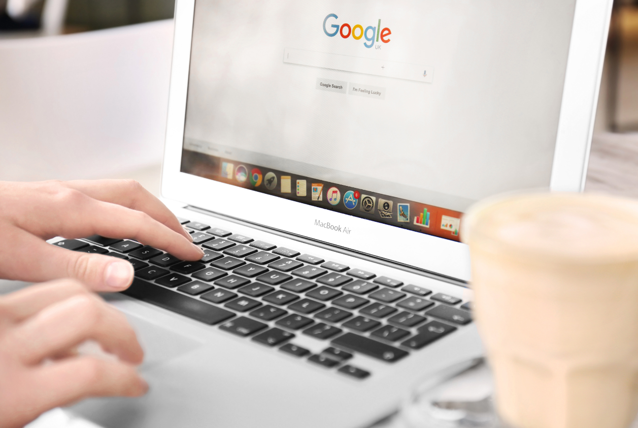Photo of laptop with hands typing on keyboard