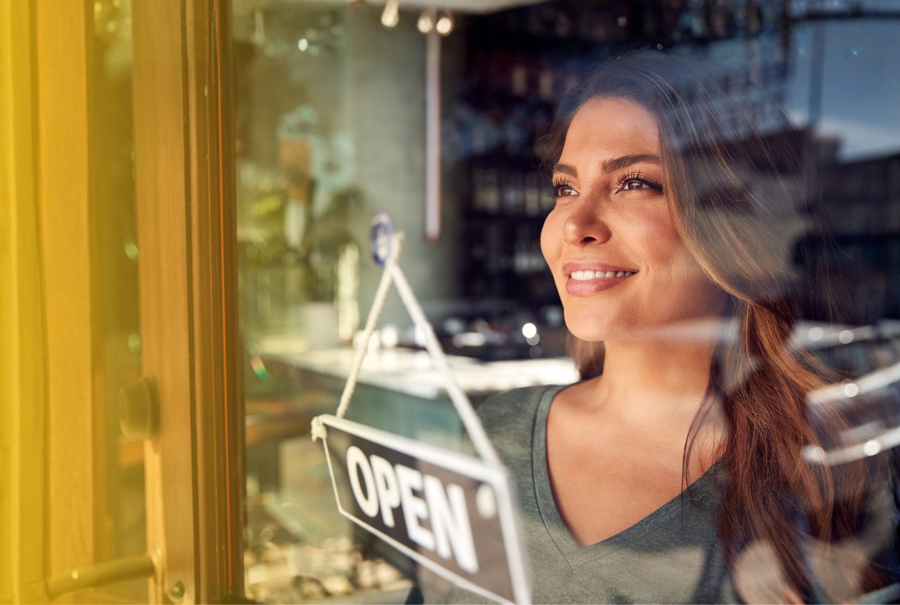 a woman looking out the window of her small business