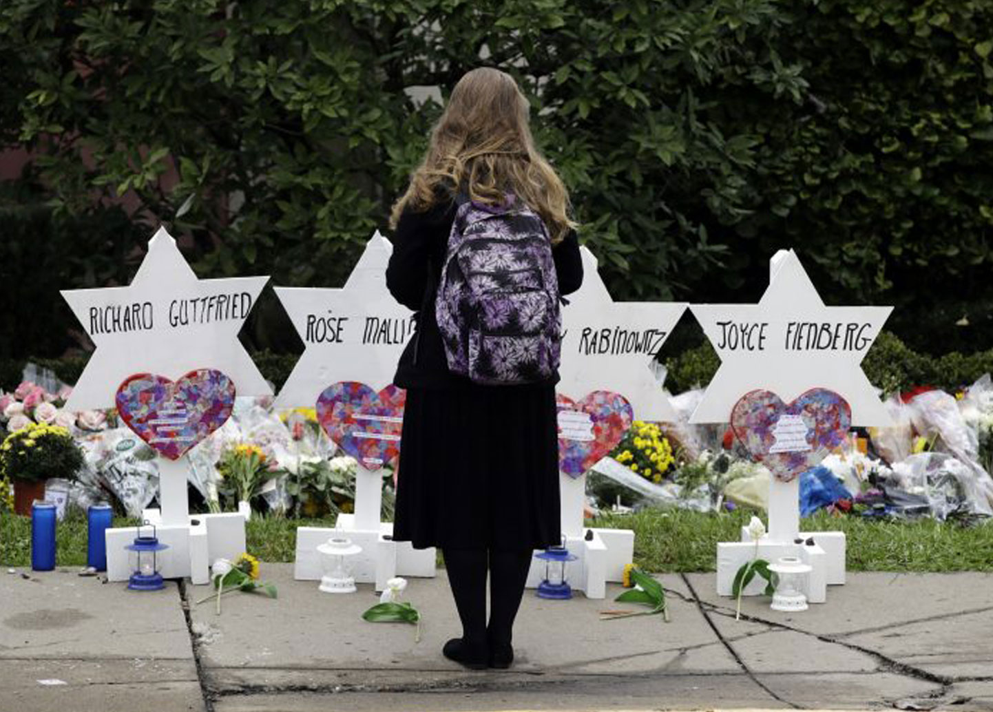 Photo of child looking at graves of victims of synagogue massacre