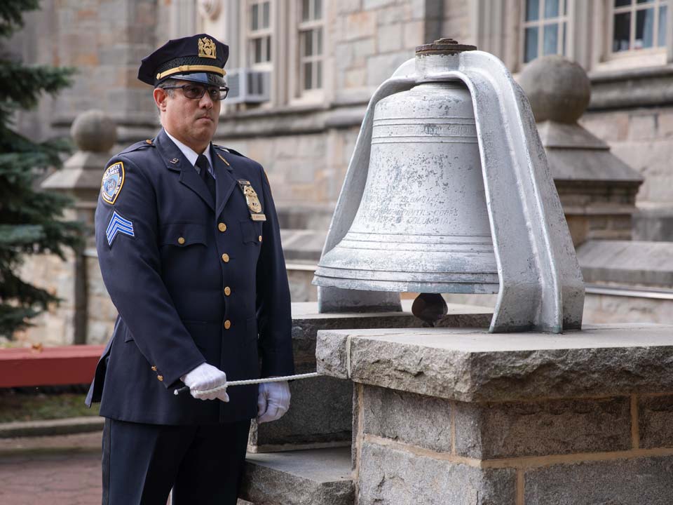 Photo of NYPD officer ringing WAVES Bell during 9/11 Remembrance Ceremony