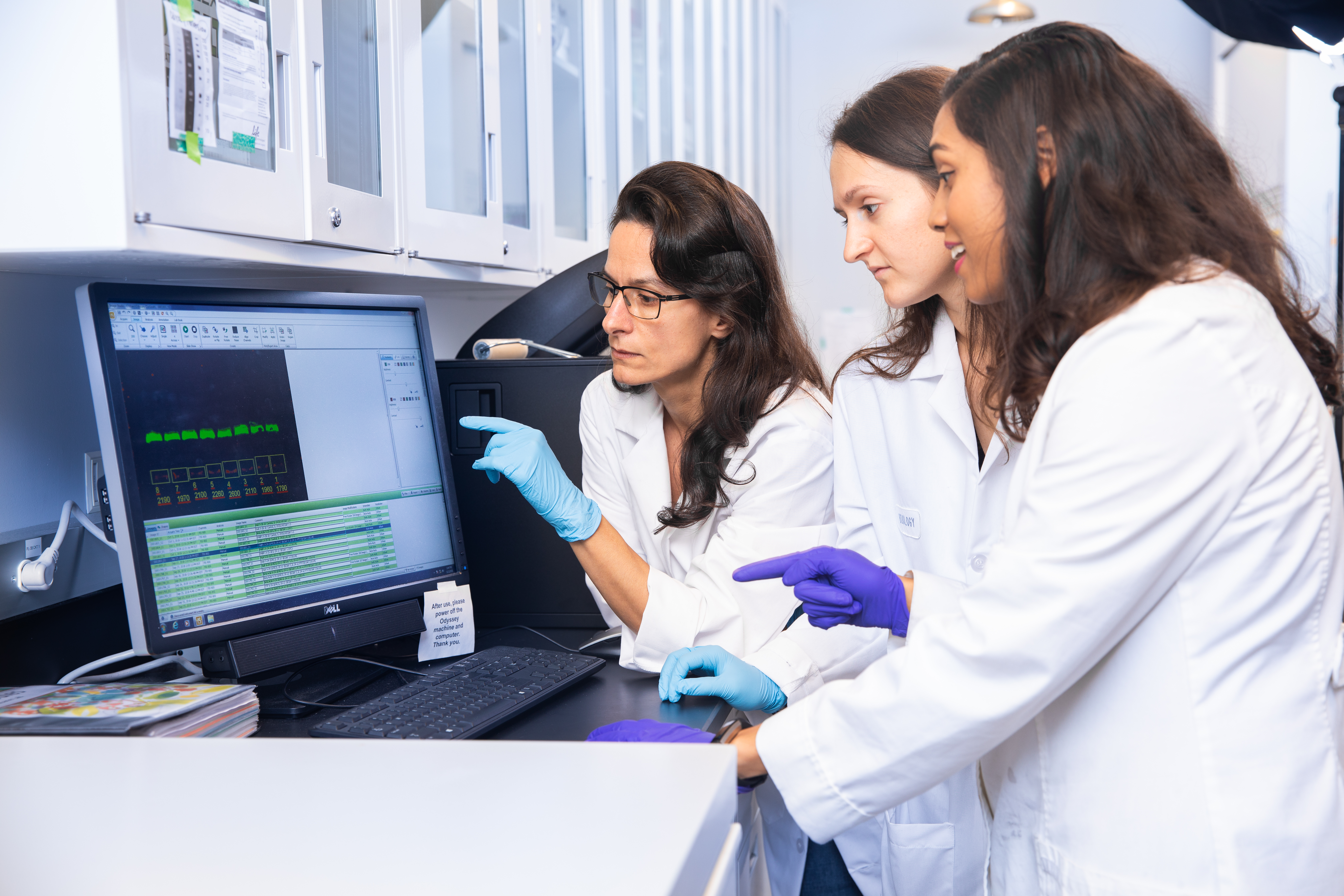 From left: Associate Professor of Biological Sciences Moira Sauane and former members of her lab, Justina Kasteri ’19 and Leah Persaud. Kasteri was accepted into medical school this year.

 