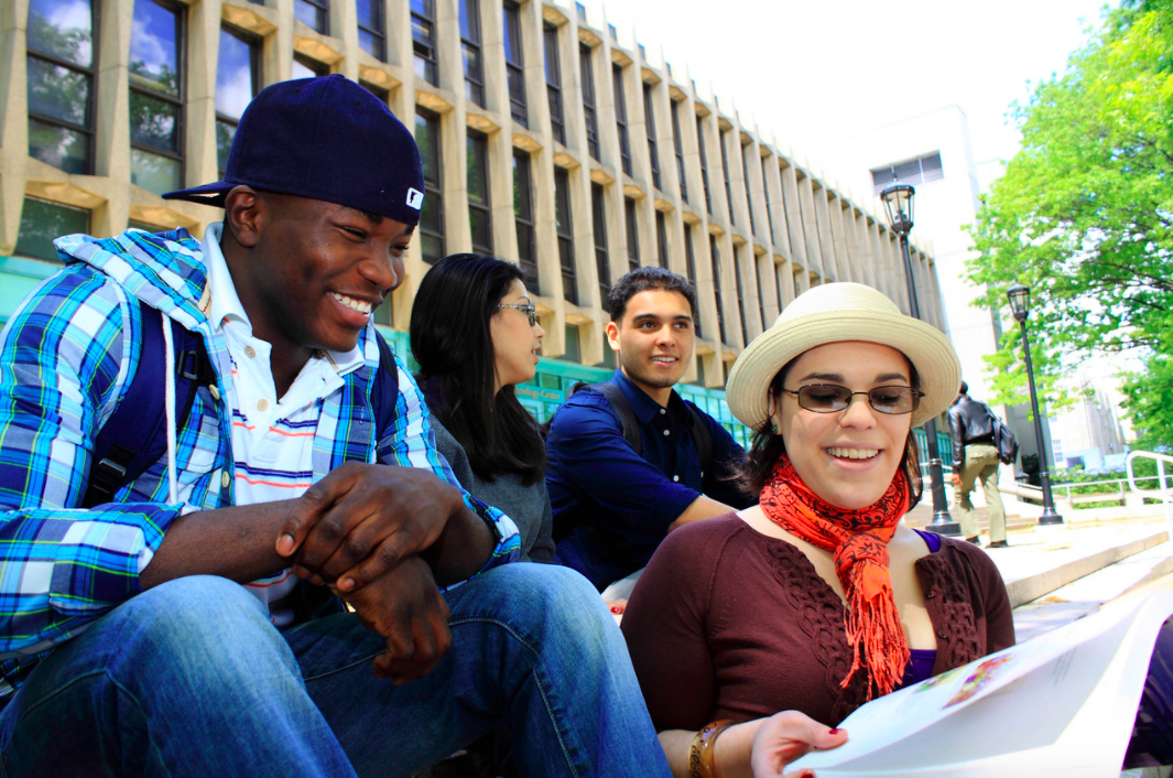 Group of students siting on steps in front of a building.