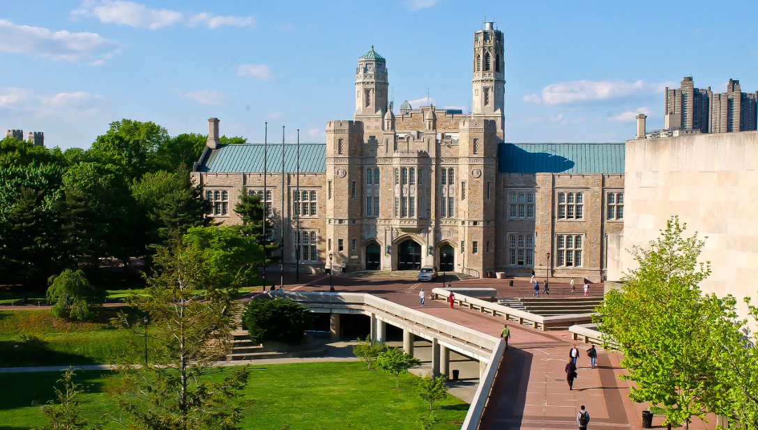 aerial photograph of Gothic-style building and people walking on pathways.