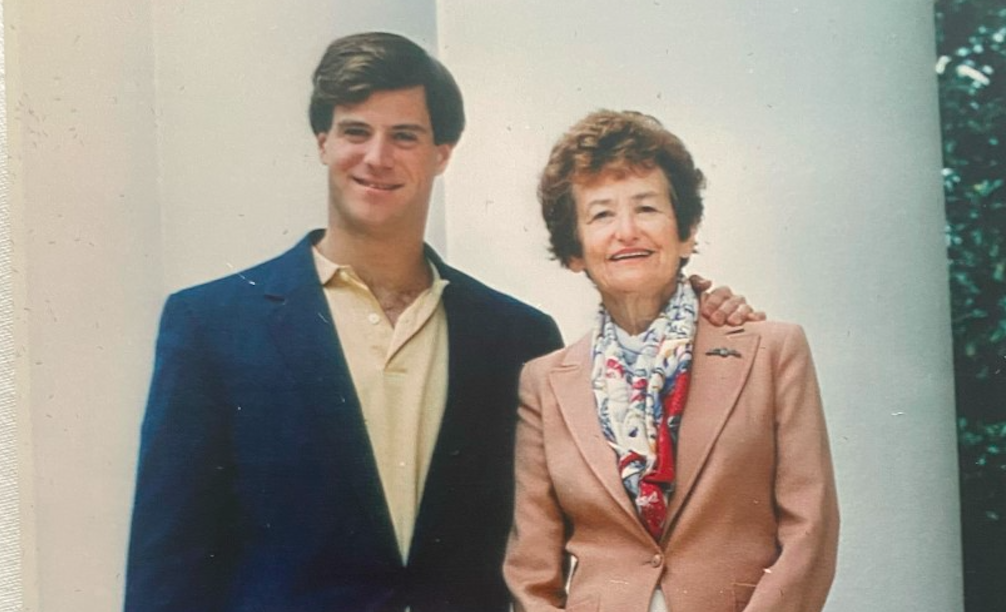 Portrait of A woman and her adult son standing close together.