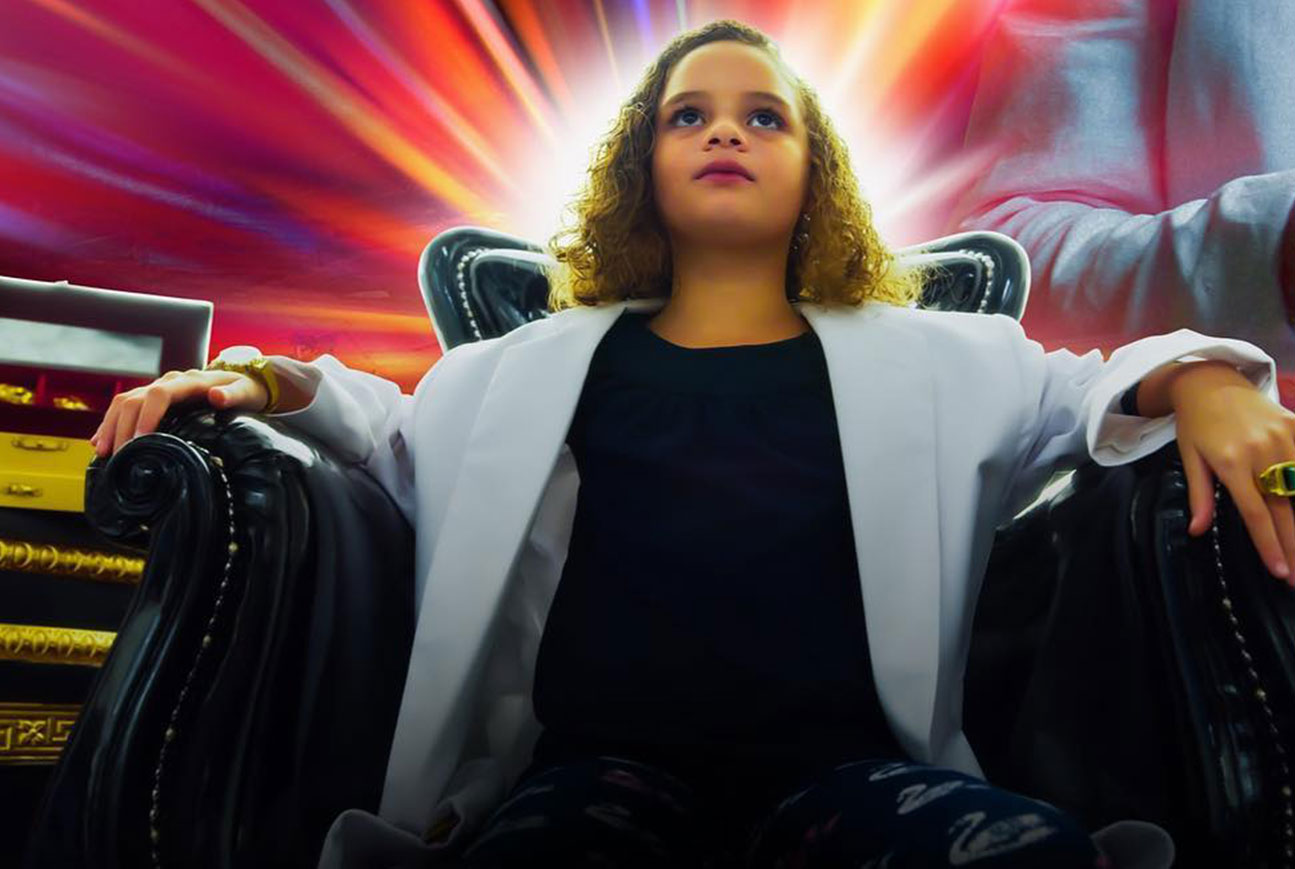 a girl sitting in a chair with the words Papi in large red font