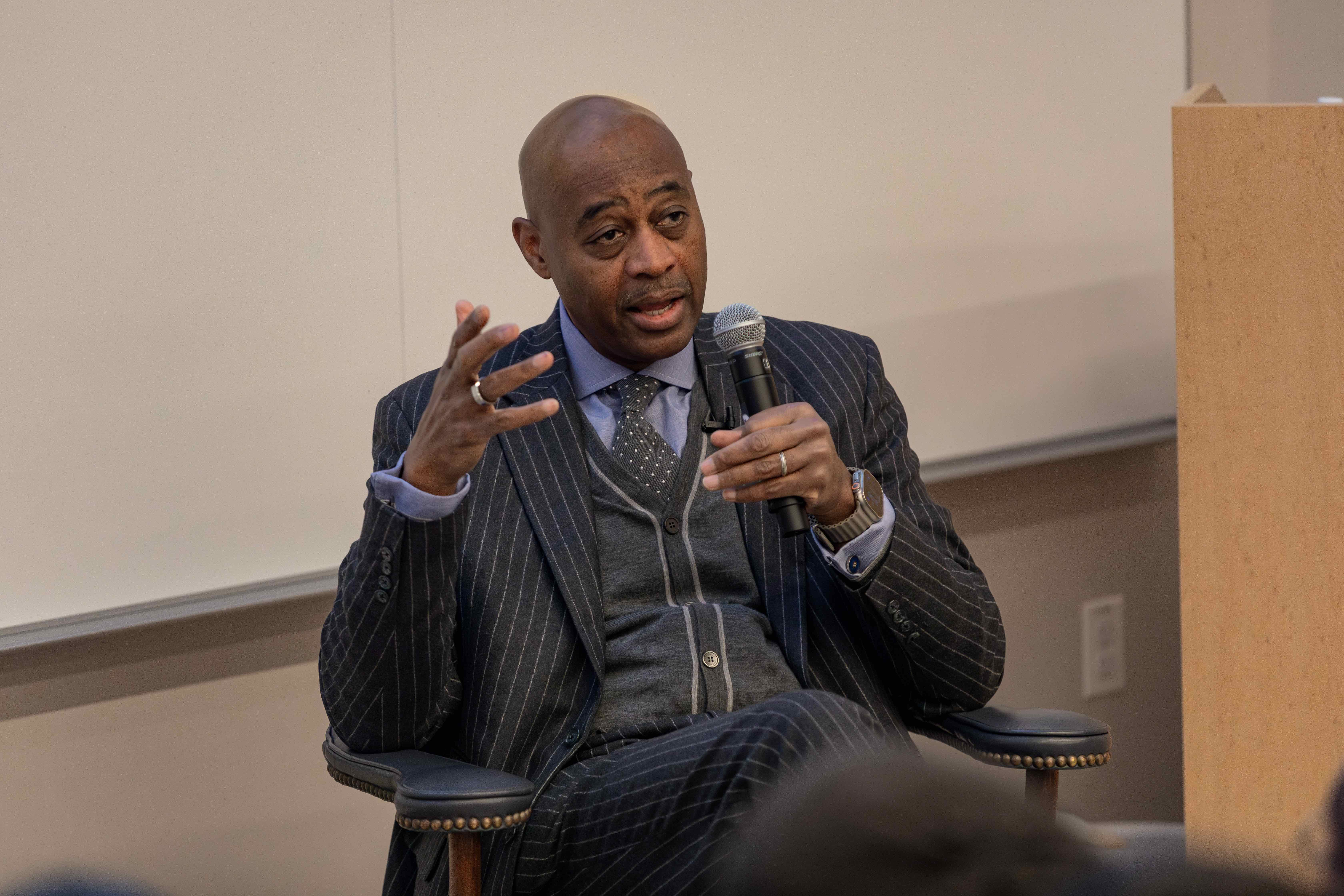 Ray McGuire, seated, speaks with students