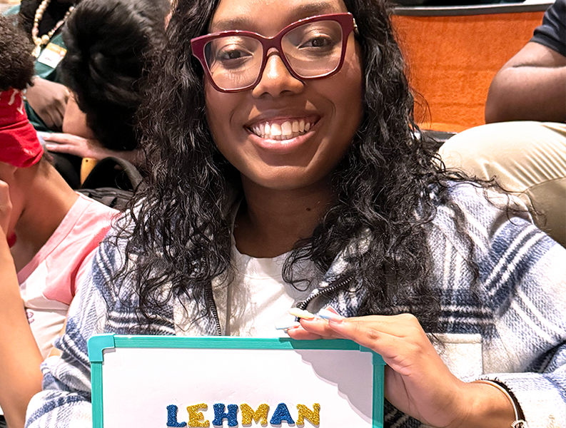 Student poses with Sign at New Student Orientation 2026