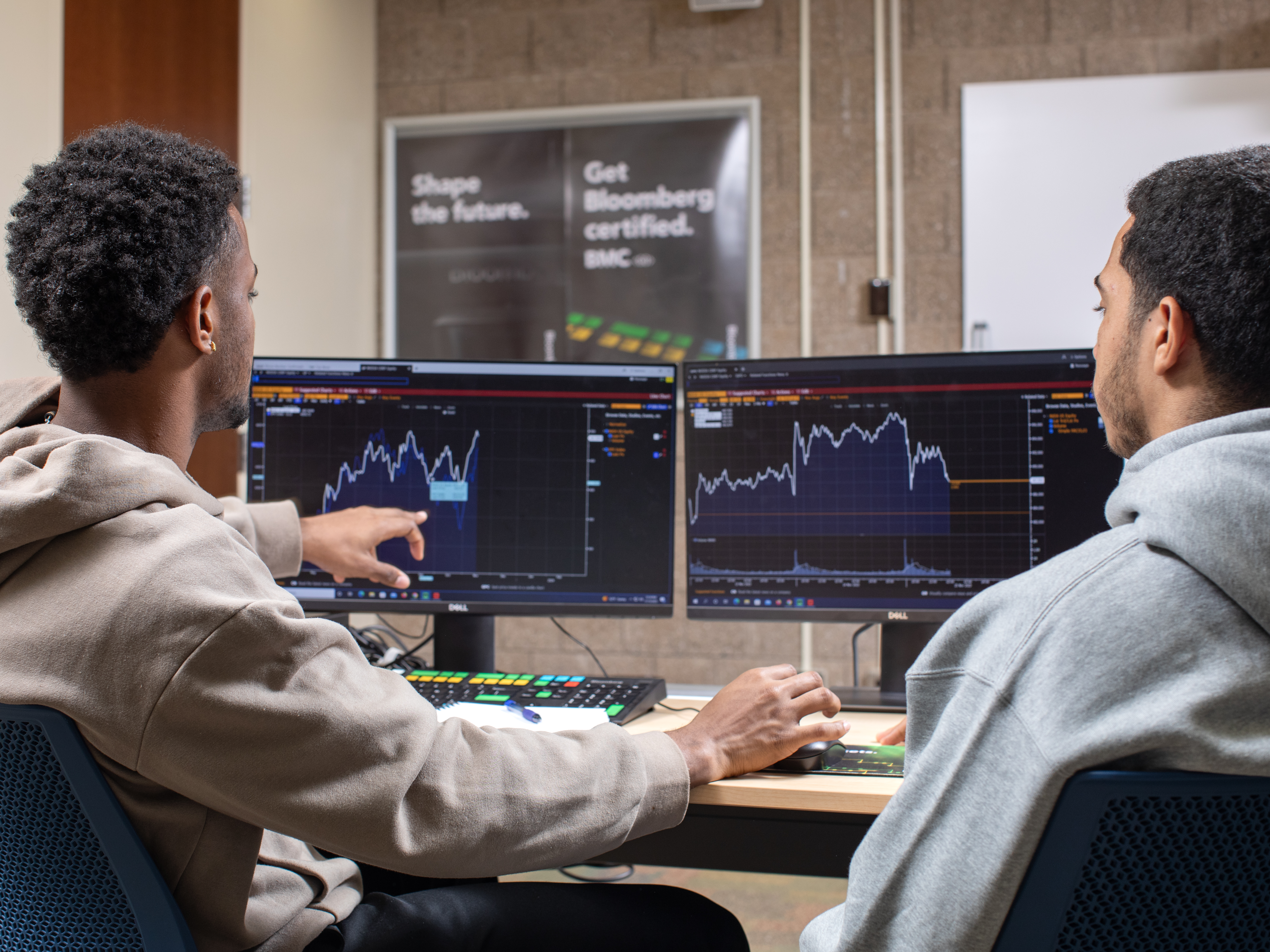 Two students working at Bloomberg Terminal computers