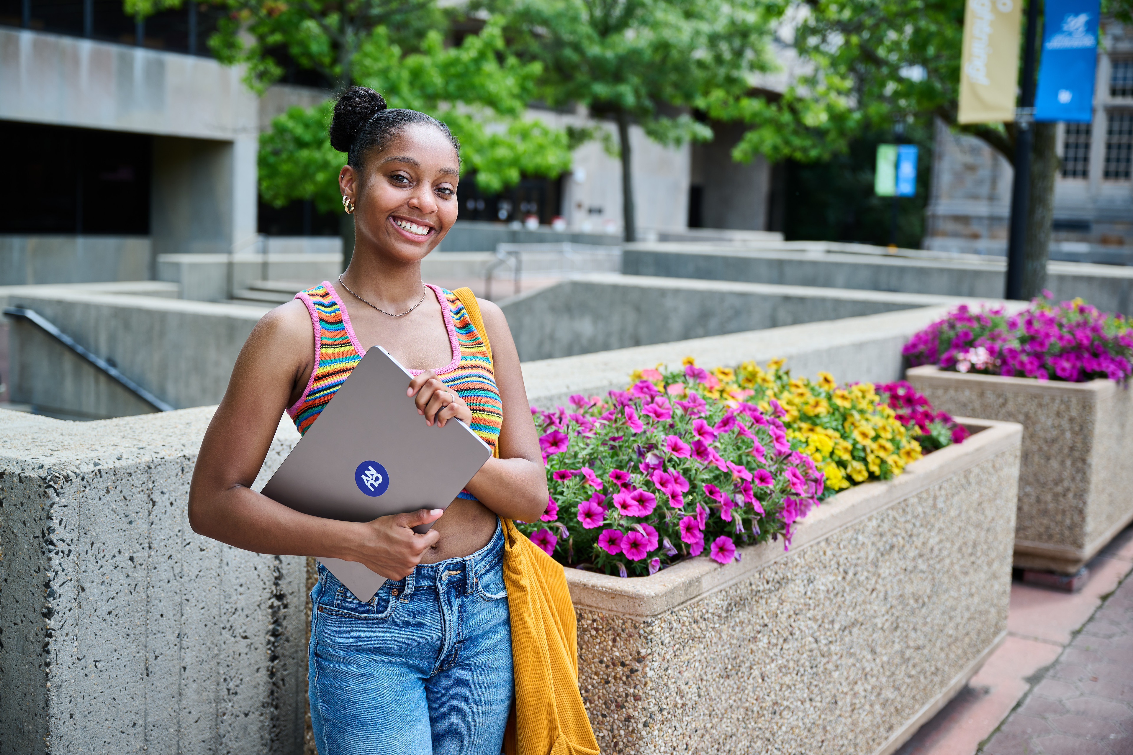 Student holding her laptop and smiling