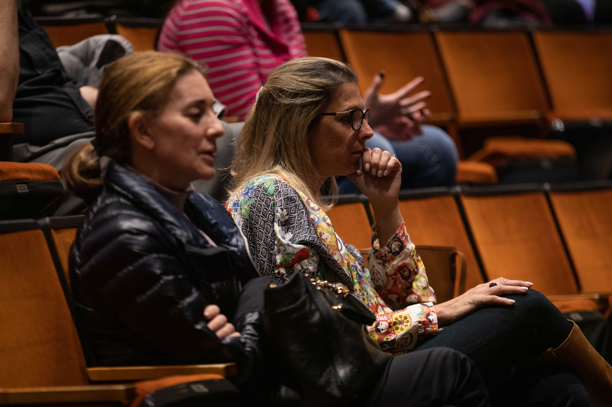 two women watching a lecture